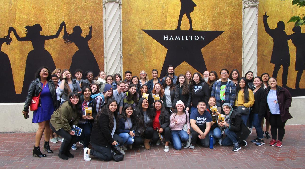 Group photo of TRIO SSS in front of Hamilton poster