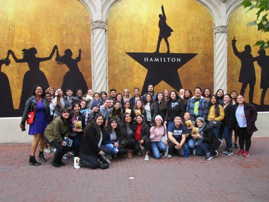 Group photo of TRIO SSS in front of Hamilton poster